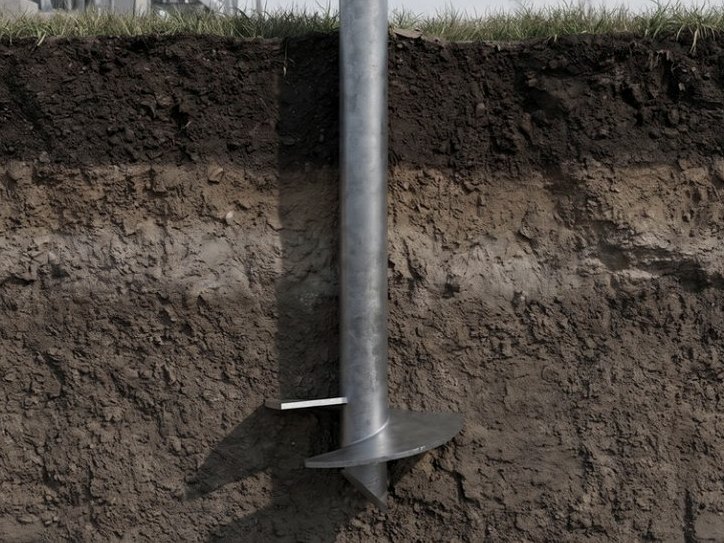 Section view below the surface, showing a prepared screw pile foundation point and its helix plate in the ground